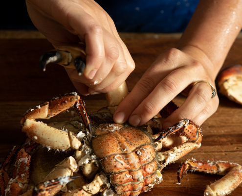 Twisting the legs off a cooked crab